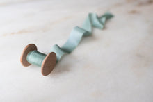 Load image into Gallery viewer, handmade and hand dyed narrow seaglass green silk ribbon by the yard and on a spool